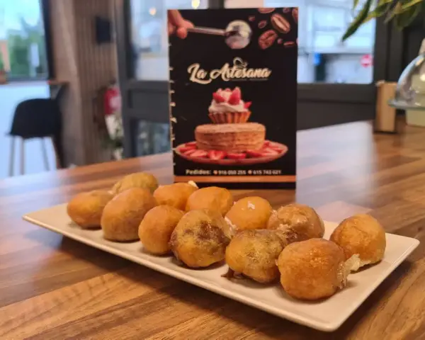 Plato de buñuelos de viento azucarados en mesa, en La Artesana, Parla