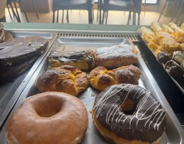 Donuts glaseados y croissants en vitrina, en La Artesana, Parla