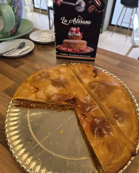 Empanada casera dorada cortada en porciones, en La Artesana, Parla