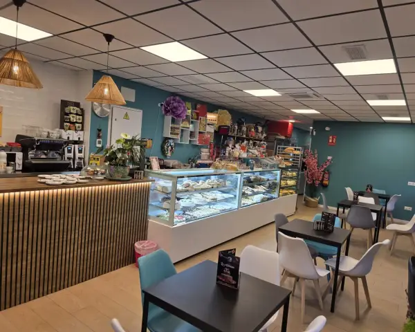 Magdalenas caseras en expositor de cristal en cafetería, en La Artesana, Parla