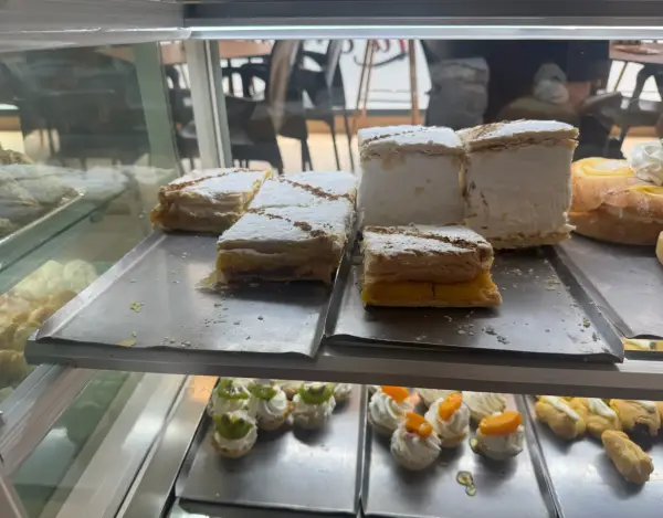 Milhojas de crema y postres de merengue en vitrina, en La Artesana, Parla