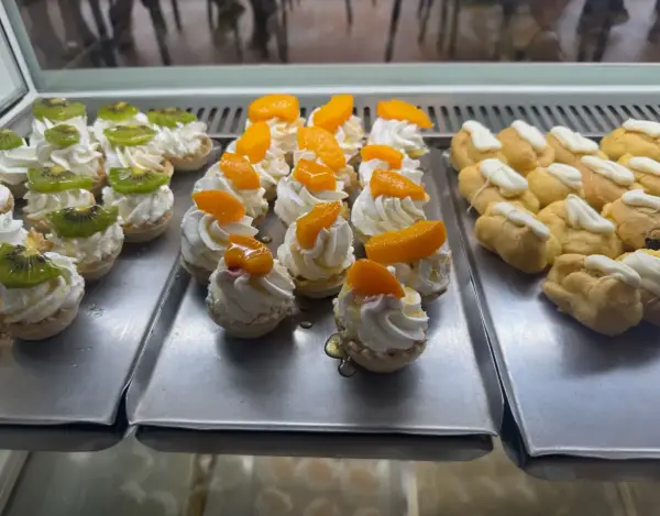 Mini tartaletas de kiwi y melocotón con profiteroles, en La Artesana, Parla