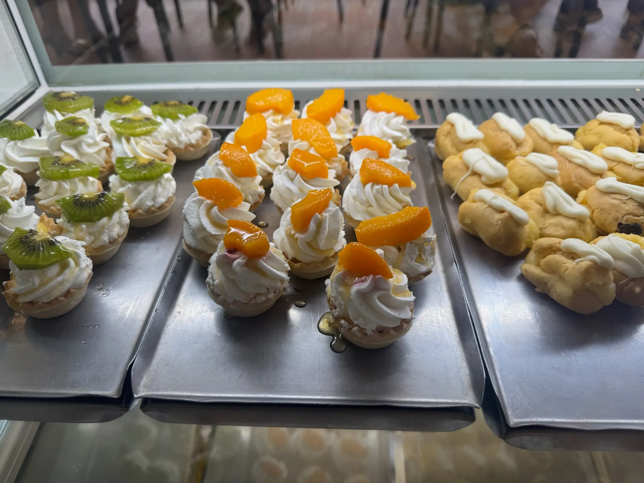 Pastelitos pequeños de nata con kiwi y melocotón