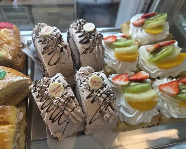 Porciones de tarta de chocolate y tartaletas de frutas, en La Artesana, Parla