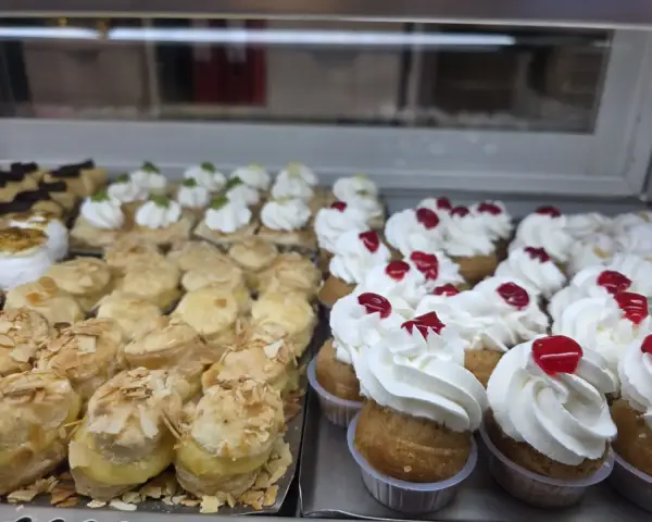 Vitrina con profiteroles, lionesas y tartaletas de nata, en La Artesana, Parla
