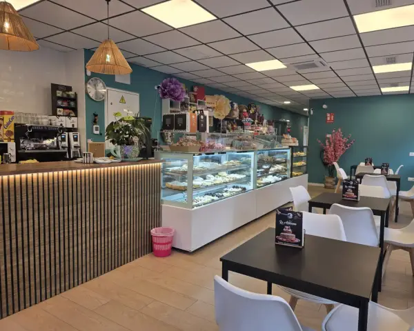 Salón interior con barra, vitrinas y mesas, en La Artesana, Parla