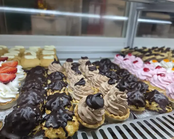 Tartaletas de crema con chocolate, nata y fresa, en La Artesana, Parla