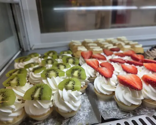 Tartaletas de nata con kiwi y fresa en vitrina, en La Artesana, Parla