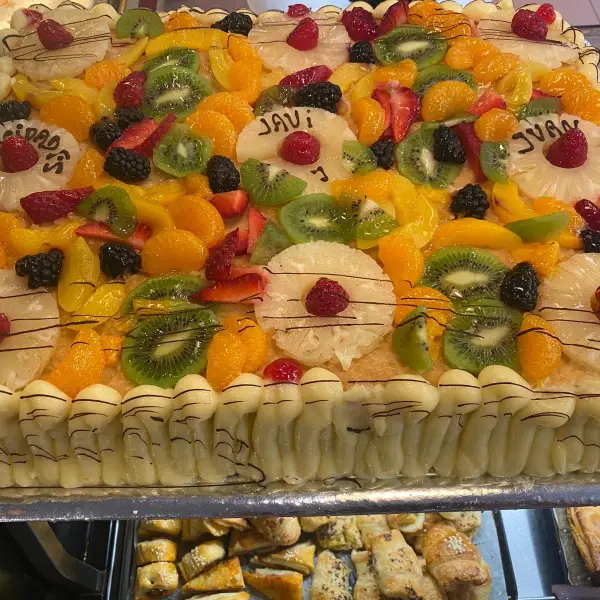 Tarta grande de frutas con kiwi y melocotón, en La Artesana, Parla