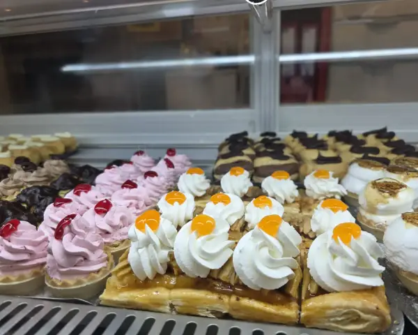Vitrina con mini tartaletas de nata y milhojas, en La Artesana, Parla