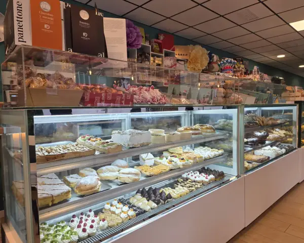 Vitrina principal repleta de tartas, pasteles y panettones, en La Artesana, Parla