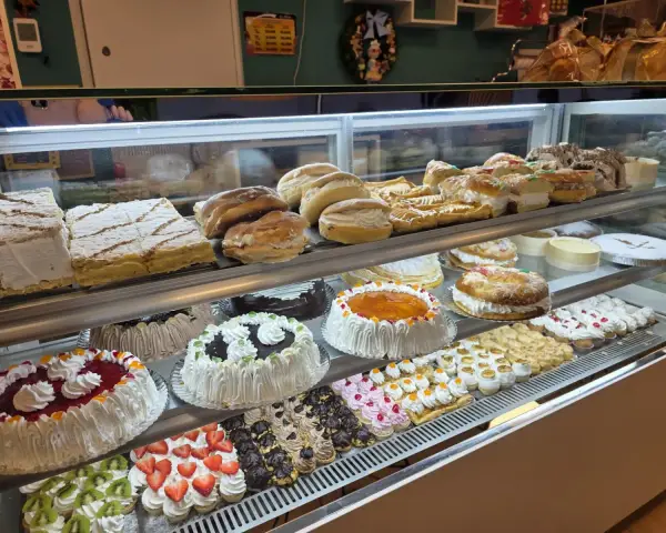 Vitrina de tartas, milhojas y mini pastelitos de frutas, en La Artesana, Parla